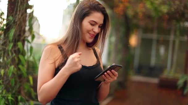 Happy Young Woman Celebrates News Holding Smartphone Girl Doing Positive — Vídeos de Stock