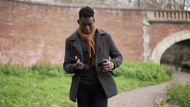 Black Man Walking Winter Season Putting Gloves Feeling Cold — стоковое видео