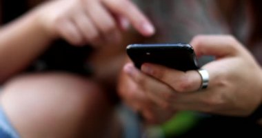 Akıllı telefonu tutan yakın plan eller. Cep telefonu kullanan insanlar