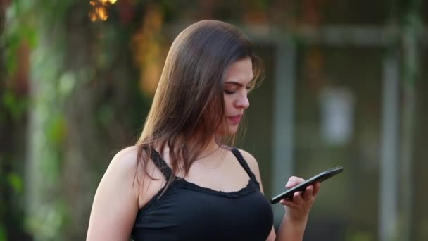 Dışarıda Akıllı Telefona Bakan Genç Bir Kadın Var Cep Telefonunu — Stok video