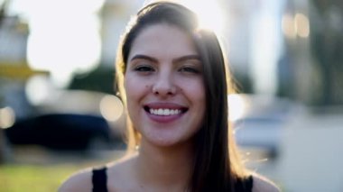 Young woman smiling at camera pretty girl natural beauty with sunlight flare