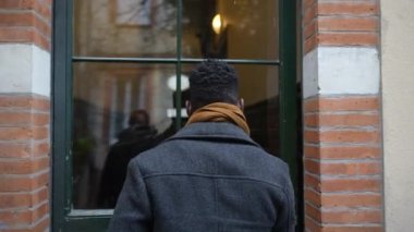 Young black man walking through corridor leaving home going outside. person leaving home