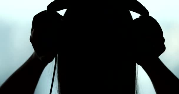 Back Woman Putting Headphones Silhouette Person Listening Music Song Podcast — Wideo stockowe