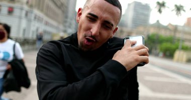 Happy hispanic man receiving good news dancing in joy