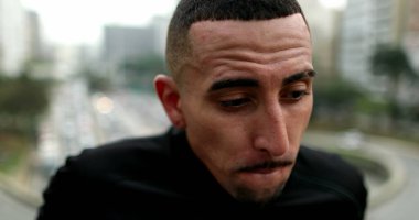 Frustrated lonely young hispanic man in city