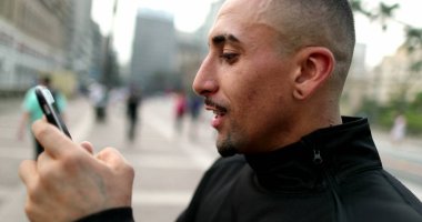 Happy hispanic man receiving good news on smartphone celebrating