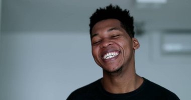 Spontaneous black man burst laughing out loud. African person authentic real life laugh and smile