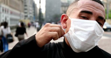 Man taking off covid-19 face mask feeling relief and satisfaction