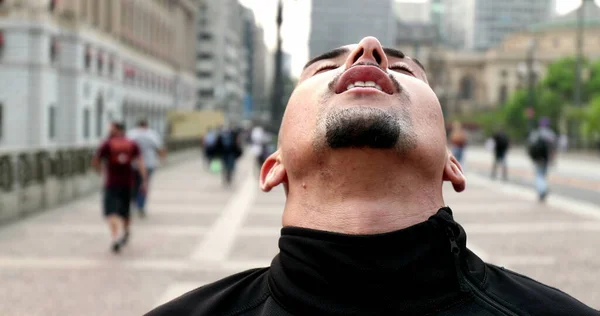 Hispanic man taking a deep breath. Latin person feeling relief and satisfaction