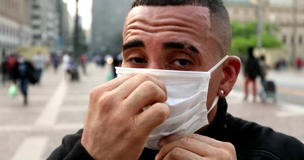 Ισπανόφωνος Άνθρωπος Βάζοντας Χειρουργική Μάσκα Προσώπου Την Πόλη Στο Παρασκήνιο — Φωτογραφία Αρχείου