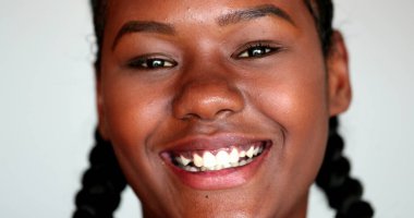 Afrikalı kız kendiliğinden gülümsüyor. Genç siyah kadın gülümsüyor. Otantik sıradan gerçek kişi