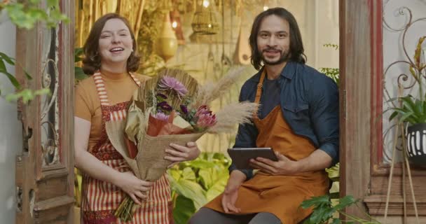 Two Employees Flower Shop Wearing Aprons Holding Tablet Bouquet Flowers — Stok video