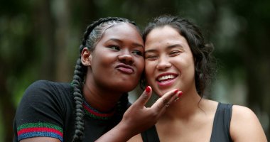 Ethnically diverse girlfriends posing together. African and hispanic girls