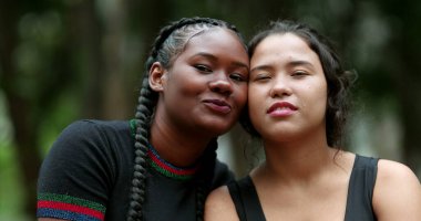 Ethnically diverse girlfriends posing together. African and hispanic girls