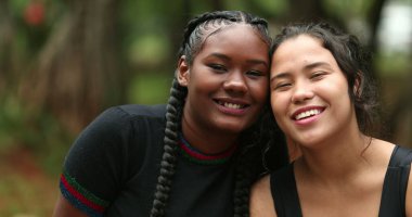Diverse girlfriends smiling at camera together. Ethnically diversity women