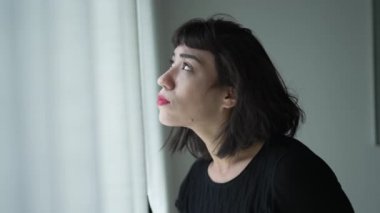 Mutlu bir İspanyol kadın pencerenin kenarında durup gülümsüyor ve güzel bir günü seyrediyor.