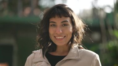 Genç bir İspanyol kadın güneş ışığıyla dışarıda duruyor. 20 'li yaşlarda Güney Amerikalı bir kızın portresi.