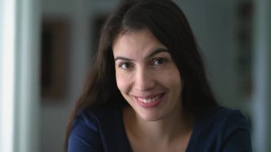 Portrait of a happy 30 year old woman looking at camera smiling. Positive expression of person