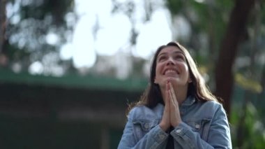 Spiritual woman feeling freedom. Person with opens arms feeling the presence of the divine standing at park