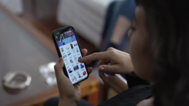 İnternetteki web sitesine bakan kişi. Cep telefonu tutan kadın alışveriş malzemesi seçiyor