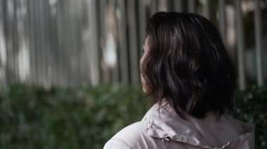 Sokakta yürüyen Latin bir Latin kızın sırtında. Genç bir kadın kaldırımda yürüyor