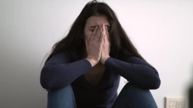 Utancıyla yüzünü kapatan kadın akıl hastalığından muzdarip. Pişmanlık ve üzüntü duyan kişi