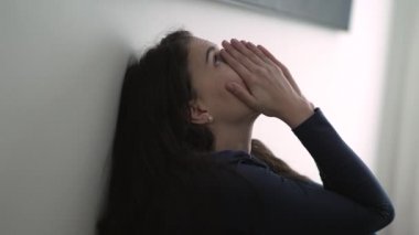 Duvara yaslanmış duygusal acıdan muzdarip biri yerde oturuyor. Zor zamanlarda bile. Stresli kadın sorun düşünüyor.