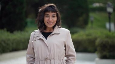 Young woman wearing jacket smiling at camera. A South American latin girl portrait face closeup