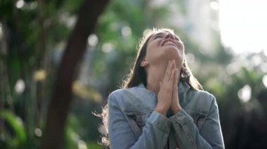 Happy woman being thankful. Spiritual girl praying looking at SKY with HOPE