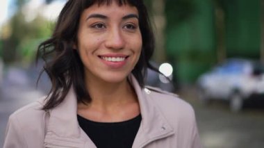 A happy Brazilian young woman walking forward smiling face closeup