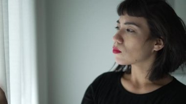 Perde camından bakan İspanyol bir kadın.