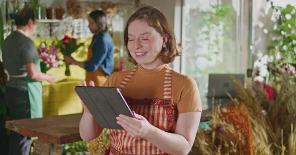 Счастливые Сотрудницы Цветочного Магазина Табличкой Проверяющей Онлайн Заказы Молодая Женщина — стоковое видео