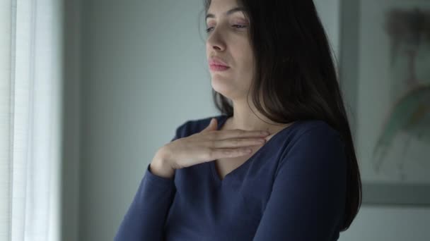 Worried Woman Standing Window Touching Her Neck Chest Seeking Comfort — стоковое видео