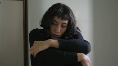Preoccupied anxious young woman. One South American hispanic girl being fearful and suffering