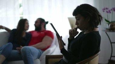Silhouette of a hispanic person reading content on the internet on her tablet device