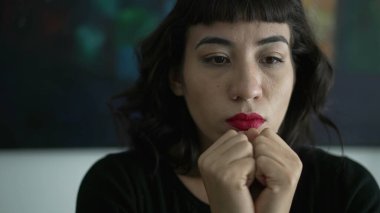 One anxious hispanic young woman closeup face. Portrait of person taking a deep breath trying to control emotion