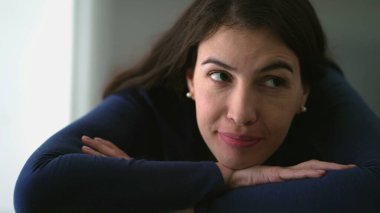 Thoughtful happy woman daydreaming. Pensive 30s person smiling leaning on table being positive about life