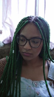 Portrait of a young hispanic black woman with Box Braid hairstyle smiling at camera