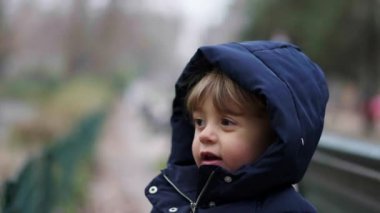 Cute child walking outside during winter season at park