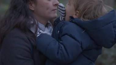 Mother kidding baby toddler boy in cheek showing love and affection