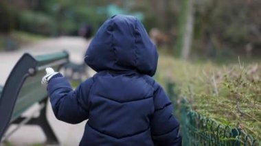 Cute child walking outside during winter season at park