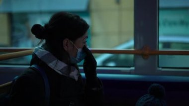 Woman wearing covid-19 face mask riding bus commuting