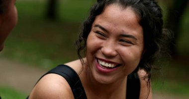Two friends real life laugh and smile together outdoors