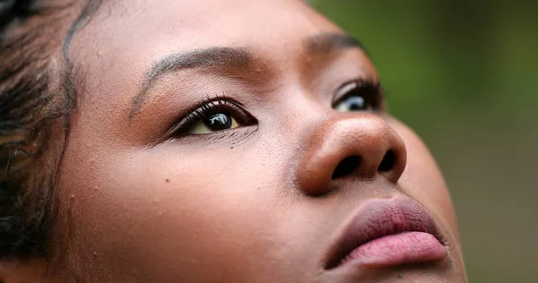 Thoughtful African woman face looking at sky in contemplation