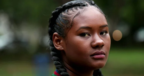 Young black African woman face, tracking shot of mixed race ethnicity girl standing outside at park