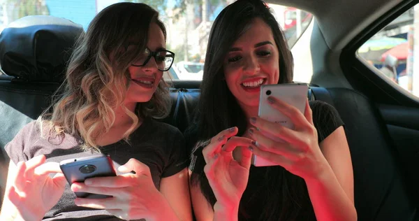 Candid Friends Back Seat Car Checking Cellphone Two Girls Looking — Stockfoto