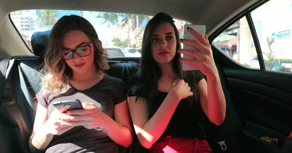 Откровенные Друзья Заднем Сиденье Машины Проверяют Свой Телефон Две Девушки — стоковое фото