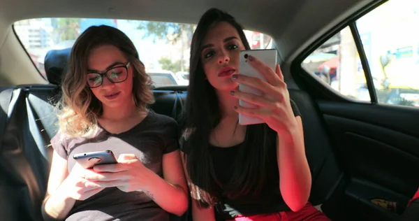 Candid Friends Back Seat Car Checking Cellphone Two Girls Looking — Foto Stock