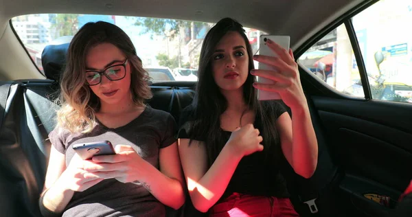 Candid Friends Back Seat Car Checking Cellphone Two Girls Looking — Stockfoto