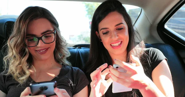 Candid Friends Holding Cellphones Back Seat Taxi Authentic Girlfriends Looking — Photo